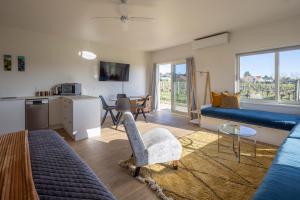 a living room with a blue couch and a kitchen at 305 in the Vines in Havelock North