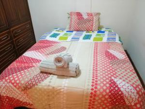 a bed with a quilt on top of it at Departamento a 10 min Terminal Quitumbe en Quito in Quito