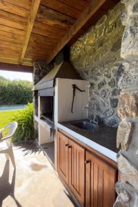 eine Küche mit einem Waschbecken und einer Steinmauer in der Unterkunft Cabañas Las Tahonas in Azul