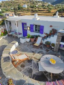 une terrasse avec des tables et des chaises ainsi qu'une maison dans l'établissement Sifnos Twin Houses, à Apollonia