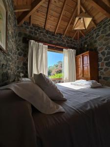 ein Schlafzimmer mit einem Bett mit Kissen und einem Fenster in der Unterkunft Cabañas Las Tahonas in Azul