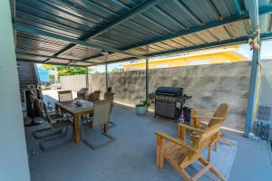 a patio with a table and chairs and a grill at One Bedroom Apartment, Private pool, huge yard in Anasco