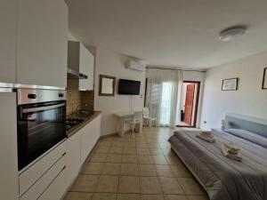 a large kitchen with a bed in a room at Open space centrale con parcheggio privato coperto in Palau
