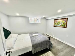 a bedroom with a bed and a picture on the wall at Basement Unit 25-Minute Downtown in Toronto