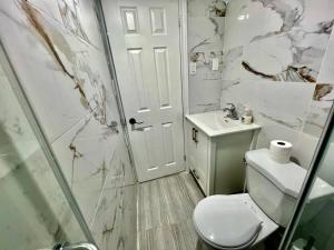 a bathroom with a toilet and a sink and a shower at Basement Unit 25-Minute Downtown in Toronto