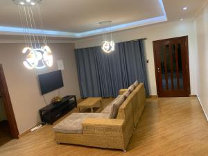 ein Wohnzimmer mit einem Sofa und einem TV in der Unterkunft House of joy Bilene in Vila Praia Do Bilene