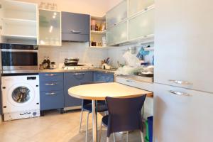 una cocina con armarios azules y una mesa con sillas en MiMa mare e centro en Milano Marittima
