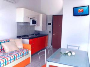 eine kleine Küche mit einem Sofa und einem Tisch in der Unterkunft Comfortable flat in a excellent location - Beahost in Bibione