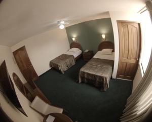 Habitación de hotel con 2 camas y escalera en Hotel La Molina, en Lima