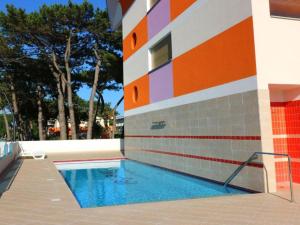 ein Pool neben einem Gebäude in der Unterkunft Comfortable flat in a excellent location - Beahost in Bibione