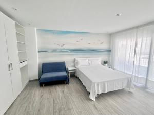 a bedroom with a bed and a blue chair at Roses Apartments Beach - 3 rooms 2baths in Roses
