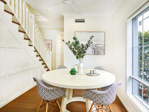 een witte eetkamer met een ronde tafel en stoelen bij Broadwater Lux home in Gold Coast