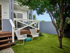 een patio met 2 stoelen, een tafel en een boom bij Broadwater Lux home in Gold Coast