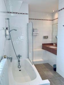 Baño blanco con bañera y lavamanos en Best Western de Diane - restaurant TAM's Cuisine Maison, en Nevers