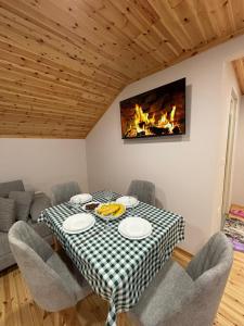 een eetkamer met een tafel en een open haard bij 2Bedroom Apartment,free parking 06 in Kamëz