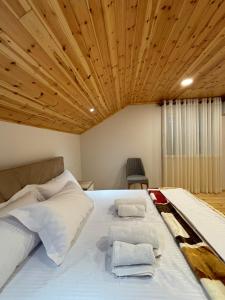 een slaapkamer met een groot wit bed en een houten plafond bij 2Bedroom Apartment,free parking 06 in Kamëz