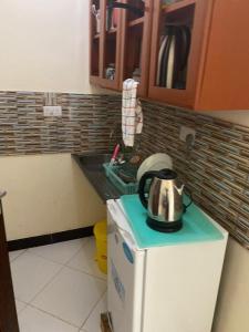 a tea kettle on top of a refrigerator in a kitchen at Maasaifari peace 4 bed in Dar es Salaam