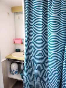 łazienka z niebiesko-białą zasłoną prysznicową w obiekcie Les Baigneuses - Piscines chauffees w mieście Saint-Hilaire-de-Talmont