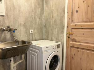 a bathroom with a washing machine and a sink at Brekke Apartments in Flåm