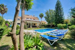 エステポナにある1106 Marbella Large Family Villaのラウンジチェアとスイミングプール付きの庭