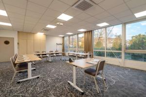 une salle de conférence avec des tables, des chaises et des fenêtres dans l'établissement Best Western Voiron Centre, à Voiron