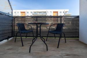 2 Stühle und ein Tisch auf dem Balkon in der Unterkunft ELEGANT Apartment Mechaniczna 5W in Głogów