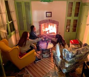 een groep mensen die voor een open haard zitten bij Greek House with Terrace - Bachman Hause in Bergama