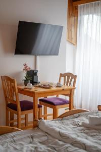 a bedroom with a desk with two chairs and a bed at S.A.W. Rooms in Schiefling am See