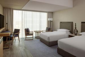 Habitación de hotel con 2 camas y escritorio en Marriott Marquis Dubai en Dubái