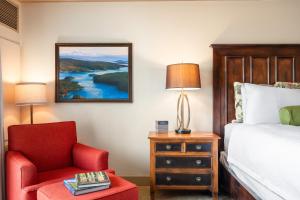 a bedroom with a bed and a red chair at Hotel Bellwether on Bellingham Bay in Bellingham