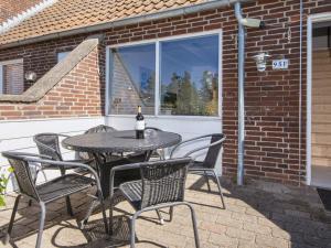 a table and chairs on a patio with a bottle of wine at Seaside Charm in Havneby - By Traum Ferienwohnungen in Rømø Kirkeby +23 photos