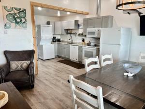 a kitchen and dining room with a table and refrigerator at Seafarer Suites in Homer