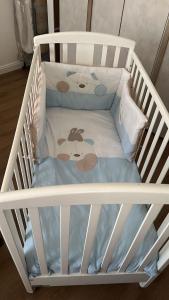 a white crib with a baby crib bedsheet and pillows at CasaTua in Catania