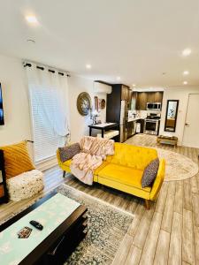 sala de estar con sofá amarillo y cocina en Eleni’s Charming Studio, en North Beach