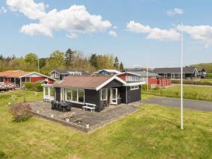 a small black house with a large yard at 7 person holiday home in Juelsminde-By Traum in Sønderby