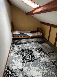 Cette petite chambre dispose d'un lit avec un tapis noir et blanc. dans l'établissement Sam, à Clermont-Ferrand