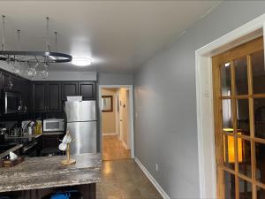 a kitchen with black cabinets and a stainless steel refrigerator at Fast internet free parking laundry and cooking nice home in Barrie