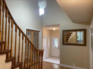 a hallway with stairs and a mirror on the wall at Fast internet free parking laundry and cooking nice home in Barrie