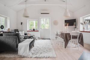 a white living room with a couch and a table at Swedish Costal Forest Hideaway in Yngsjö