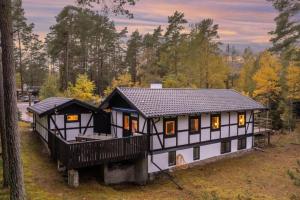 a black and white house in the woods at Swedish Costal Forest Hideaway in Yngsjö