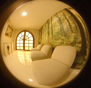 Habitación circular con sillas blancas y pared en Hotel La Molina en Lima