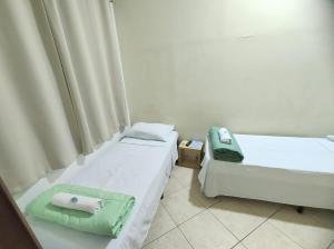 duas camas num quarto com toalhas em Pousada Catarina em Biguaçu