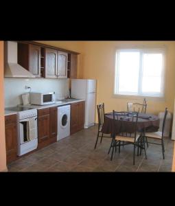 a kitchen with a table and a kitchen with a table and chairs at Sunny Villa in Dobrich