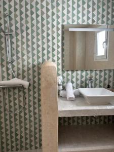 a bathroom with a sink and a mirror at RIAD OASIS D'ASILAH in Asilah