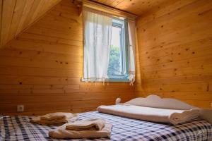 イヴァニツァにある"Naše Brdo" - Ivanjicaの木製の部屋にベッド1台が備わるベッドルーム1室があります。