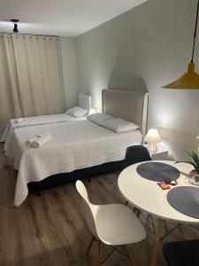 een slaapkamer met een bed en 2 tafels en stoelen bij AP Smart Center in Campinas