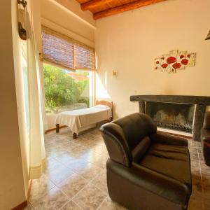 a living room with a chair and a fireplace at Cabaña privada en Valle Grande San Rafael in Valle Grande