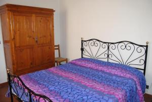 a bedroom with a bed and a wooden cabinet at La Ginestra in Pienza