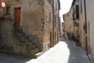 un callejón con escaleras en un edificio antiguo en La Ginestra, en Pienza