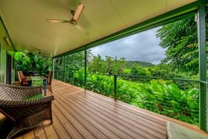 a balcony with a view of the jungle at Mena Creek Flower House in Mena Creek